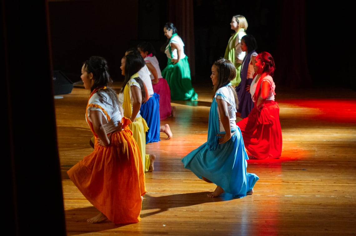 Dancers performing a Madagascar-style dance with each dancer wearing a different color dress.