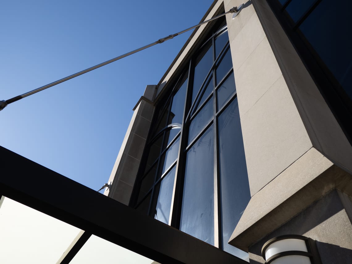 A photo of a building with various cables, windows, frames, creating geometrical architectural shapes.